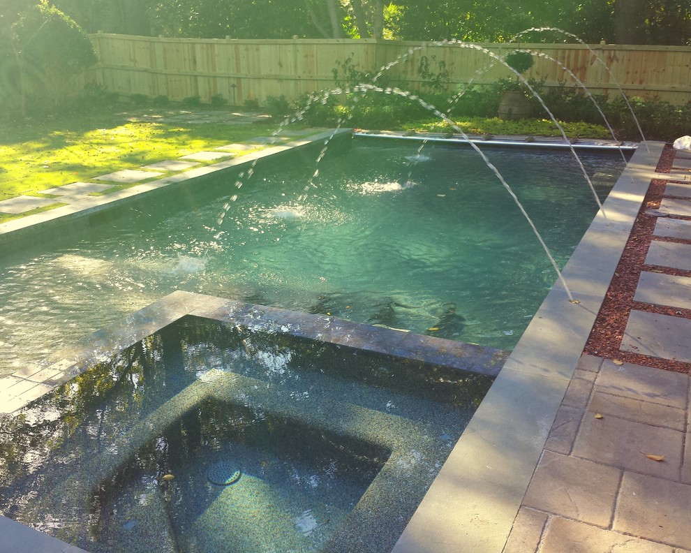 Ispirazione per una piccola piscina contemporanea rettangolare dietro casa con fontane e pavimentazioni in pietra naturale