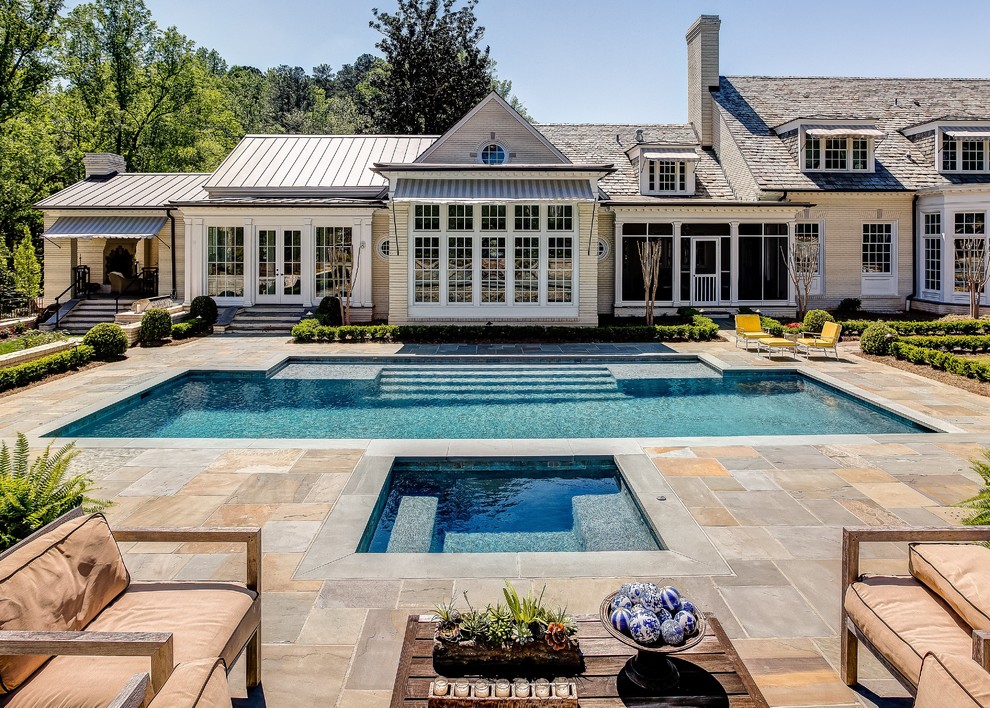 Imagen de piscina clásica grande rectangular en patio trasero con adoquines de piedra natural