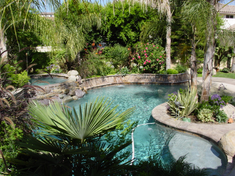 Example of a large tuscan backyard stone and custom-shaped natural hot tub design in Los Angeles