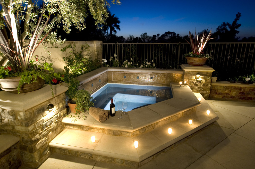 Esempio di una piscina chic personalizzata di medie dimensioni e dietro casa con una vasca idromassaggio e lastre di cemento
