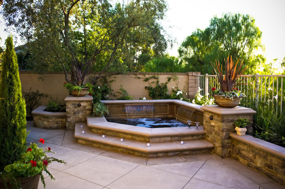 Inspiration for a medium sized world-inspired back custom shaped hot tub in Los Angeles with concrete slabs.