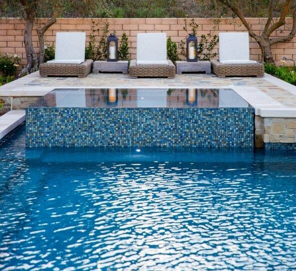 Ejemplo de piscinas y jacuzzis alargados actuales grandes rectangulares en patio trasero con adoquines de piedra natural
