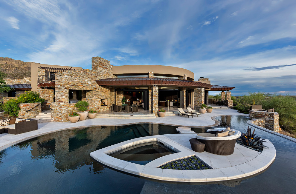 Пример оригинального дизайна: бассейн произвольной формы на заднем дворе в современном стиле с джакузи и мощением тротуарной плиткой