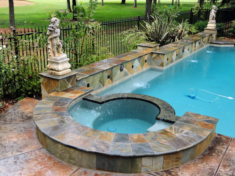 Esempio di una grande piscina naturale mediterranea personalizzata dietro casa con una vasca idromassaggio e cemento stampato