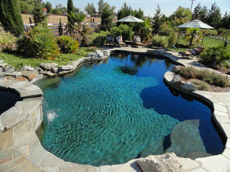 Großer Moderner Pool hinter dem Haus in individueller Form mit Natursteinplatten in Sacramento