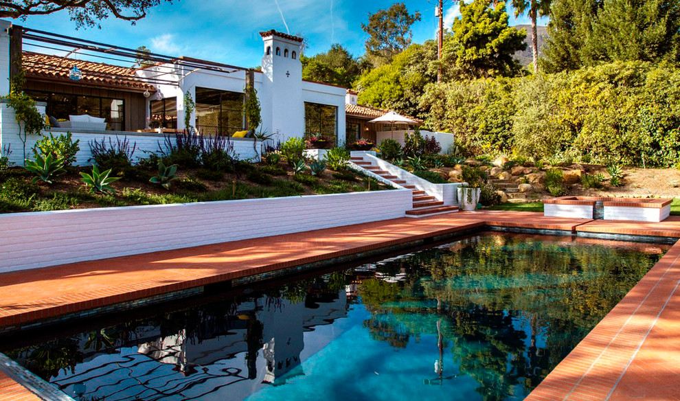 Immagine di una piscina monocorsia mediterranea rettangolare di medie dimensioni e dietro casa con una vasca idromassaggio e pavimentazioni in mattoni