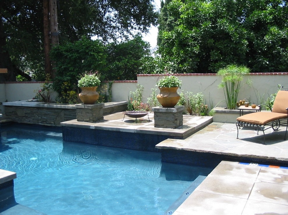 Immagine di una piscina monocorsia minimalista personalizzata di medie dimensioni e dietro casa con fontane e pavimentazioni in pietra naturale