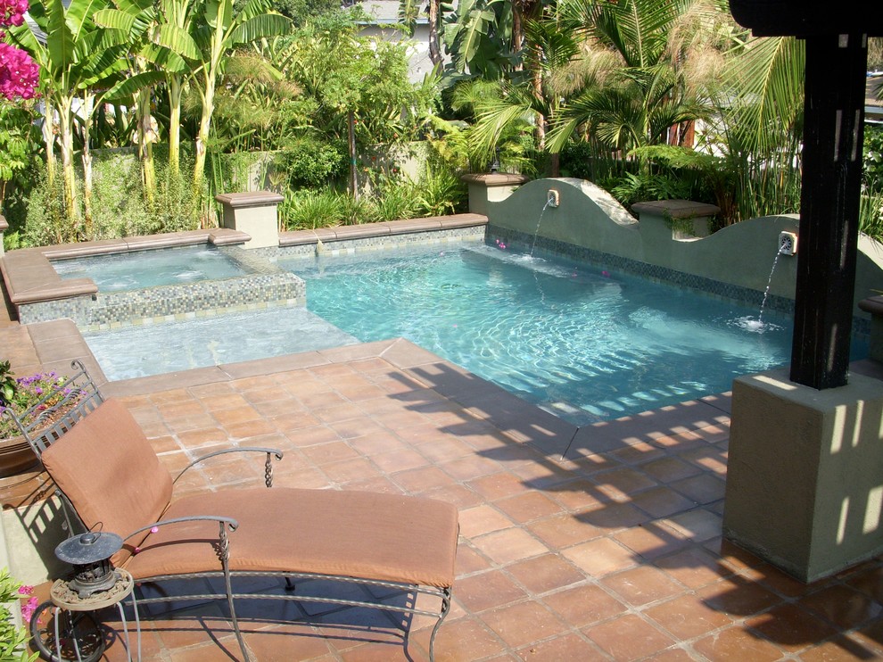Esempio di una piscina a sfioro infinito minimalista personalizzata di medie dimensioni e dietro casa con fontane e lastre di cemento