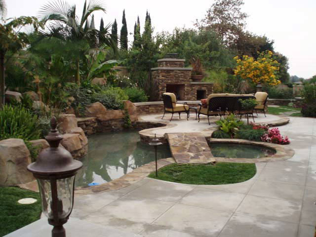 Foto di una grande piscina a sfioro infinito chic personalizzata dietro casa con piastrelle e fontane