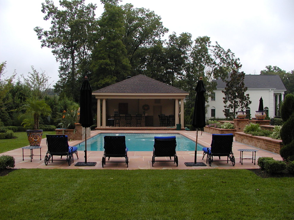 Immagine di una piscina naturale tradizionale rettangolare di medie dimensioni e dietro casa con pavimentazioni in pietra naturale