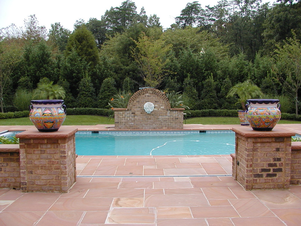 Esempio di una grande piscina naturale classica rettangolare dietro casa con pavimentazioni in pietra naturale