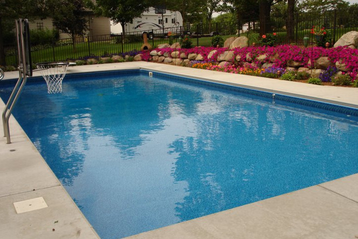 Esempio di una grande piscina monocorsia chic rettangolare dietro casa con fontane e cemento stampato