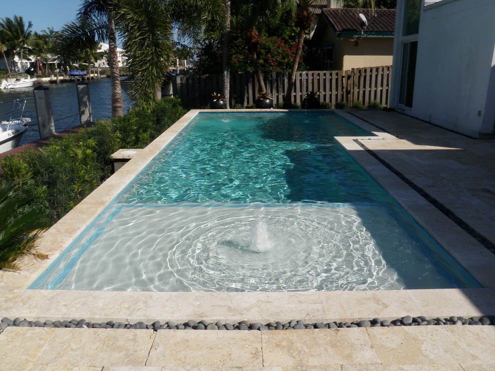 Inspiration for a mid-sized backyard stone and rectangular pool fountain remodel in Miami