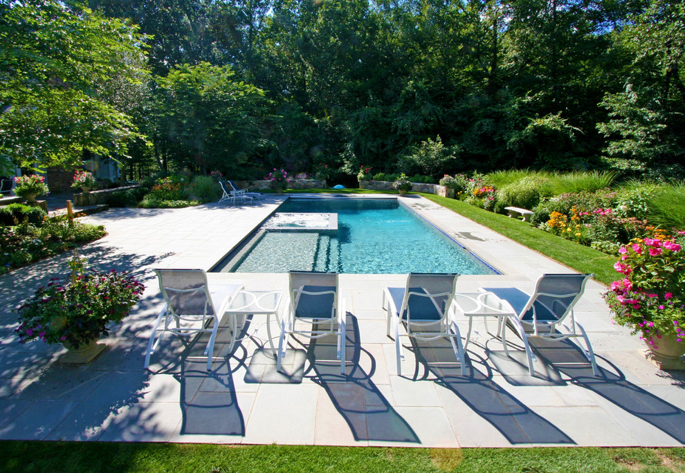 Foto de piscinas y jacuzzis rectangulares en patio trasero con adoquines de piedra natural