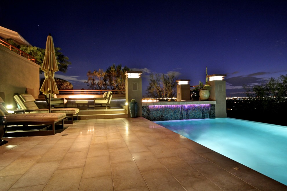 Foto di una grande piscina monocorsia design rettangolare dietro casa con fontane e piastrelle
