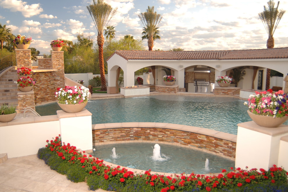 Immagine di un'ampia piscina monocorsia mediterranea personalizzata dietro casa con un acquascivolo e piastrelle