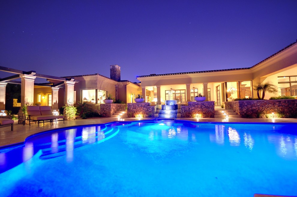 Esempio di una grande piscina monocorsia mediterranea rettangolare dietro casa con fontane e piastrelle
