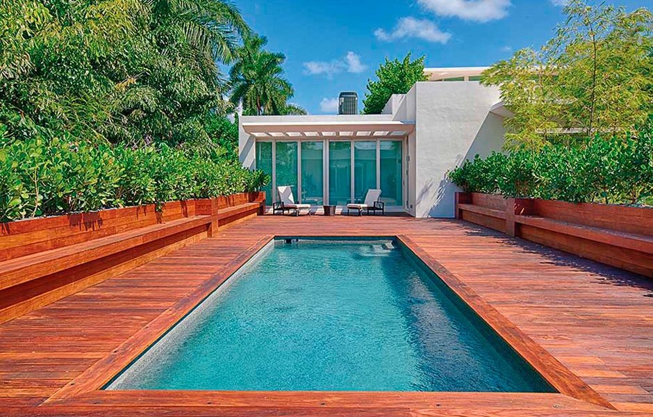 Diseño de piscina rectangular en patio trasero con entablado