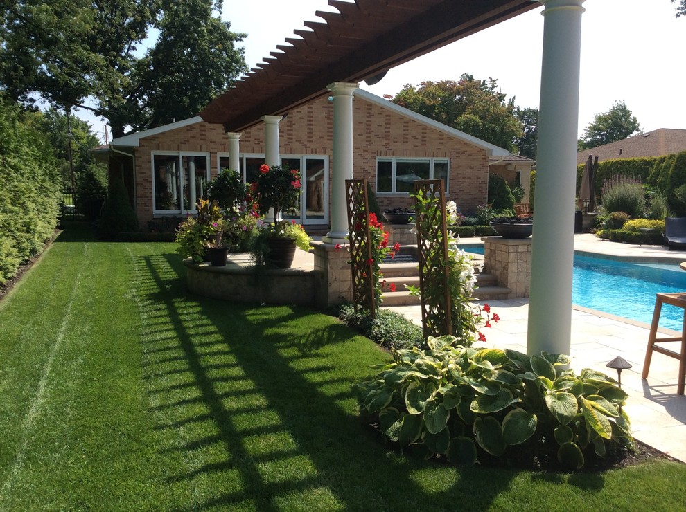Example of a mid-sized classic backyard stone and rectangular pool design in Cleveland