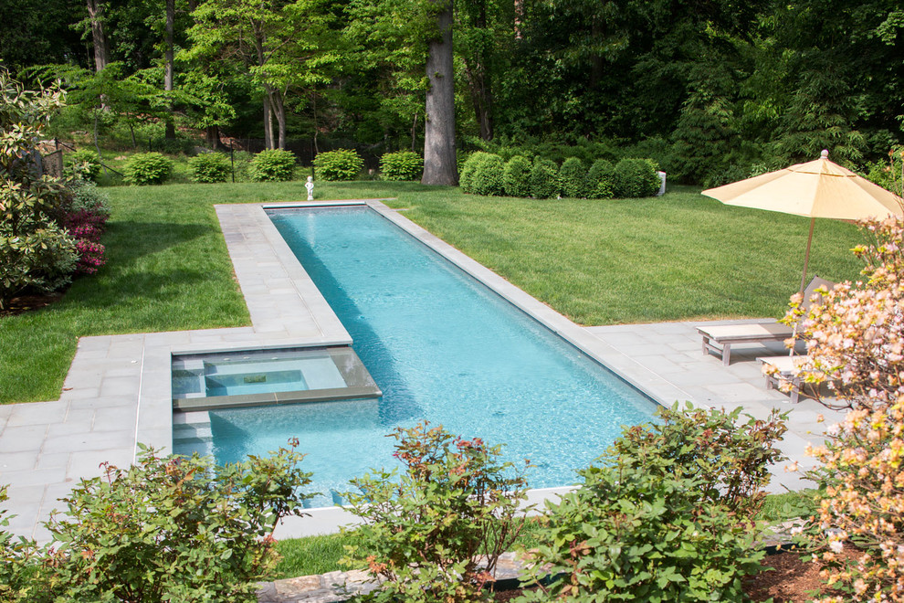 Idee per una piscina monocorsia minimal rettangolare di medie dimensioni e dietro casa con una vasca idromassaggio e pavimentazioni in pietra naturale