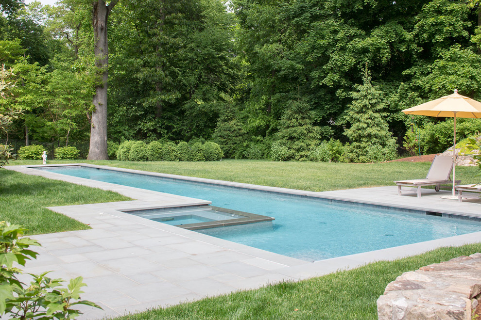 Ispirazione per una piscina monocorsia contemporanea rettangolare di medie dimensioni e dietro casa con una vasca idromassaggio e pavimentazioni in pietra naturale