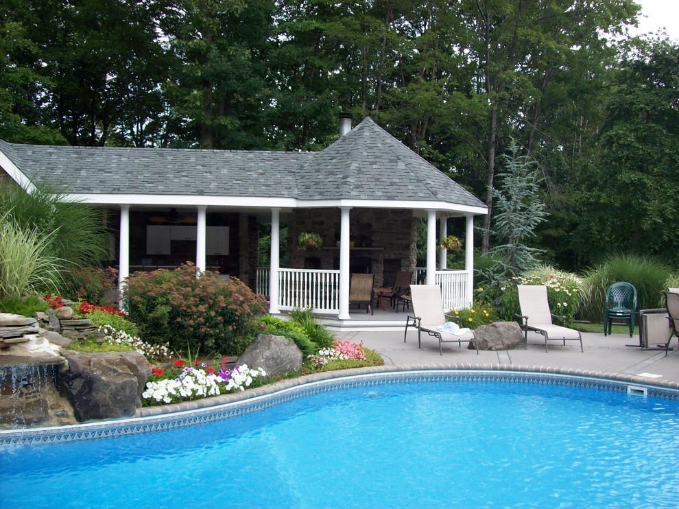 Large elegant backyard concrete and custom-shaped pool photo in New York