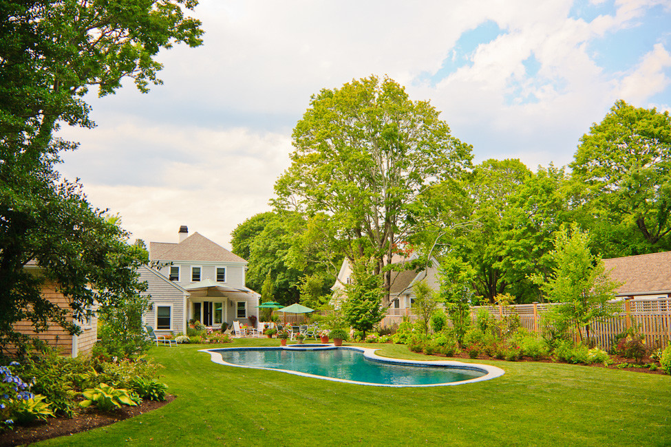 Esempio di una piscina chic a "C" di medie dimensioni e dietro casa con una vasca idromassaggio e pavimentazioni in pietra naturale