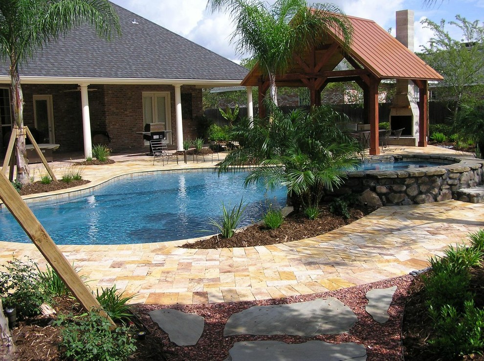 Foto de piscina tradicional renovada grande a medida en patio trasero con suelo de baldosas