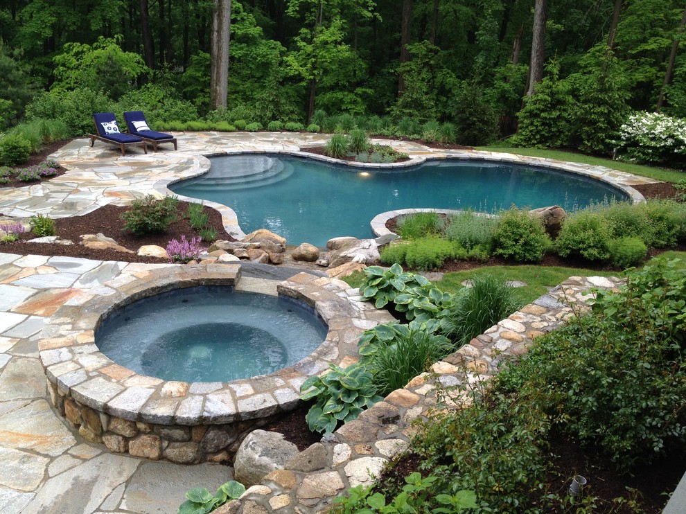 Inspiration for a timeless backyard stone and custom-shaped pool remodel in New York