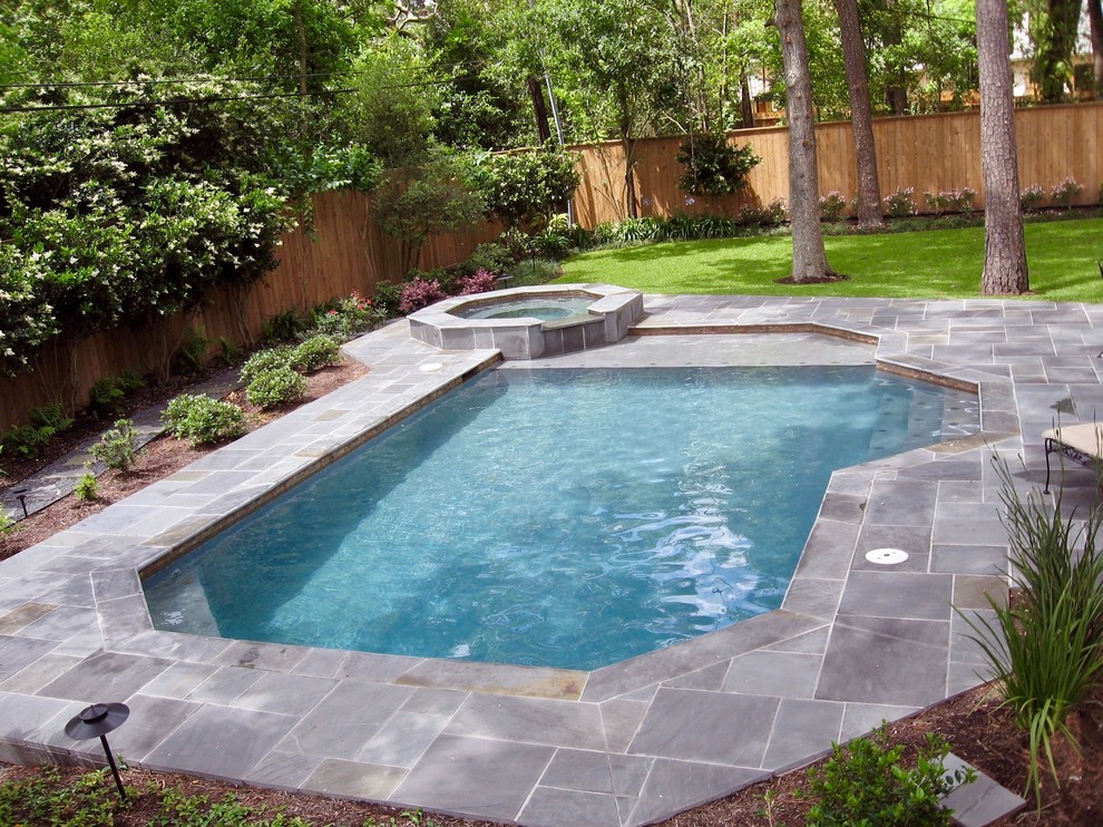 Esempio di una piscina monocorsia tradizionale rettangolare di medie dimensioni e dietro casa con una vasca idromassaggio e piastrelle