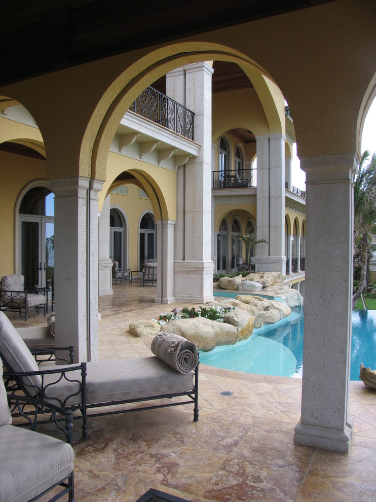 На фото: бассейн среднего размера на заднем дворе в средиземноморском стиле с покрытием из плитки