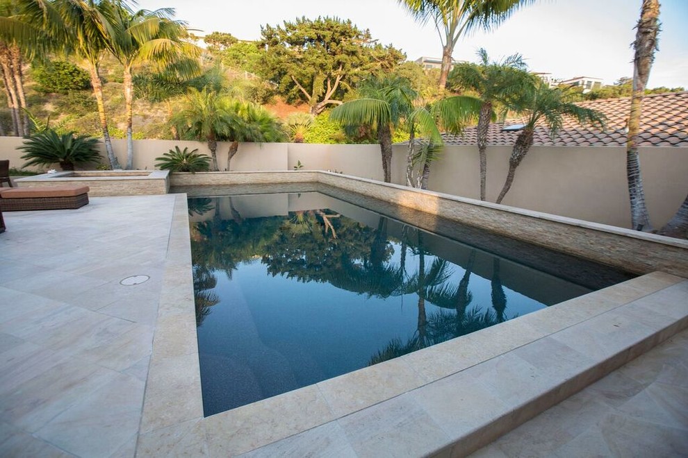 Foto de piscinas y jacuzzis actuales grandes rectangulares en patio trasero con losas de hormigón