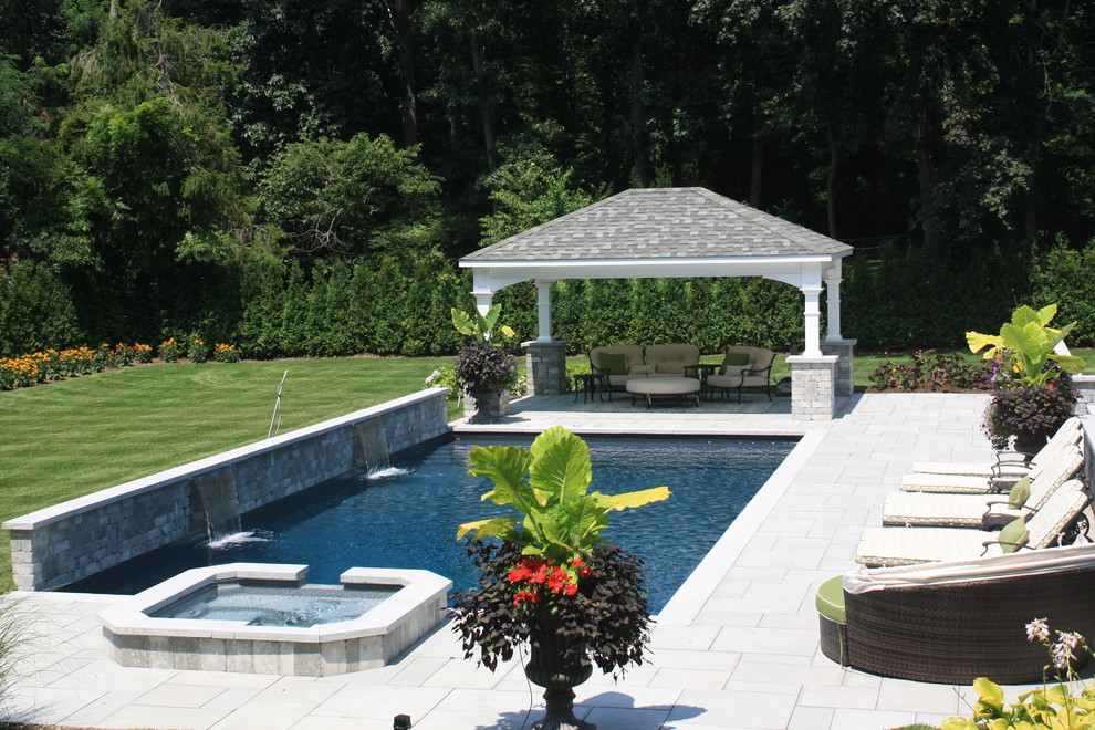 Стильный дизайн: большой естественный, прямоугольный бассейн на заднем дворе в современном стиле с фонтаном и покрытием из каменной брусчатки - последний тренд