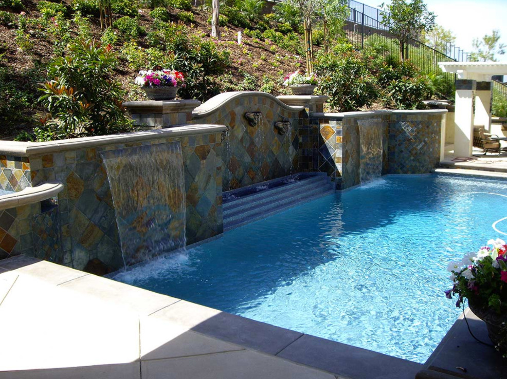 Foto de piscina con fuente natural mediterránea de tamaño medio a medida en patio trasero con losas de hormigón