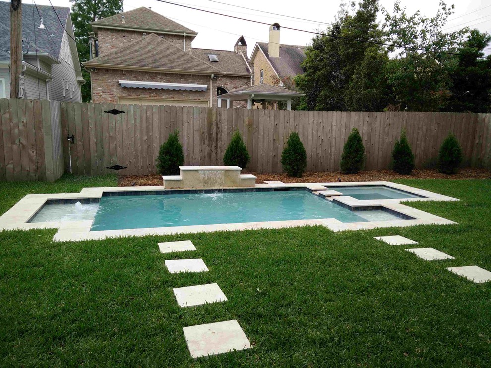 Exemple d'une petite piscine naturelle et arrière chic sur mesure avec des pavés en pierre naturelle.