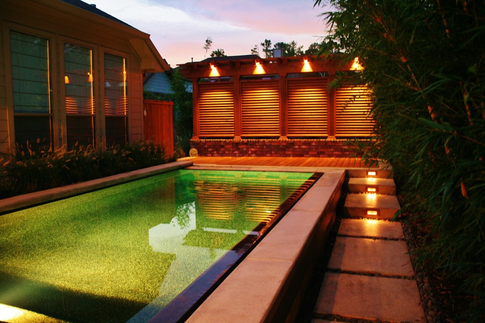 Idée de décoration pour une petite piscine arrière et à débordement minimaliste rectangle avec une terrasse en bois et un point d'eau.
