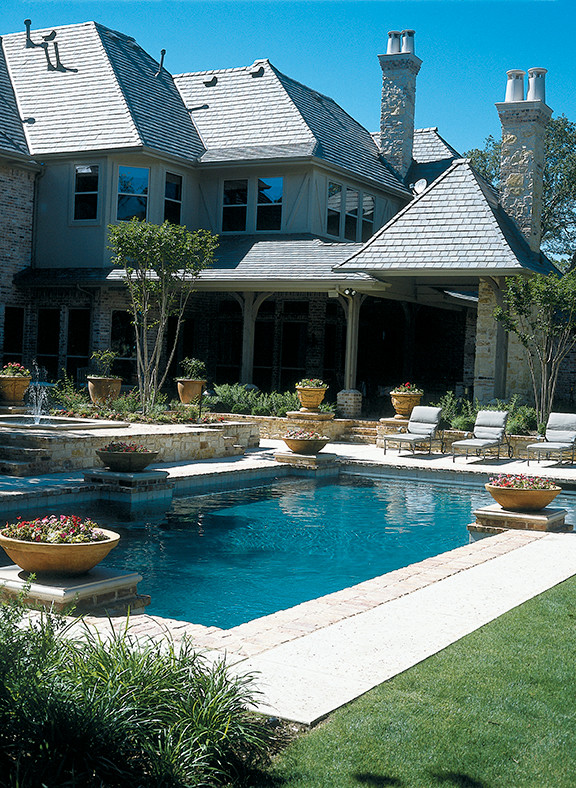 Immagine di una piscina naturale classica di medie dimensioni e dietro casa con una vasca idromassaggio e pavimentazioni in pietra naturale