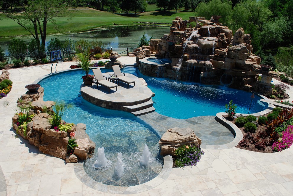 Example of a large island style backyard stone and custom-shaped hot tub design in Chicago
