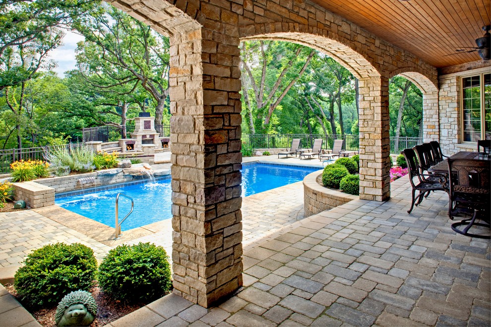 Esempio di una piscina monocorsia tradizionale rettangolare di medie dimensioni e dietro casa con una dépendance a bordo piscina e pavimentazioni in mattoni