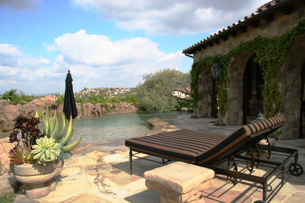 Idee per una piscina naturale mediterranea personalizzata con pavimentazioni in pietra naturale
