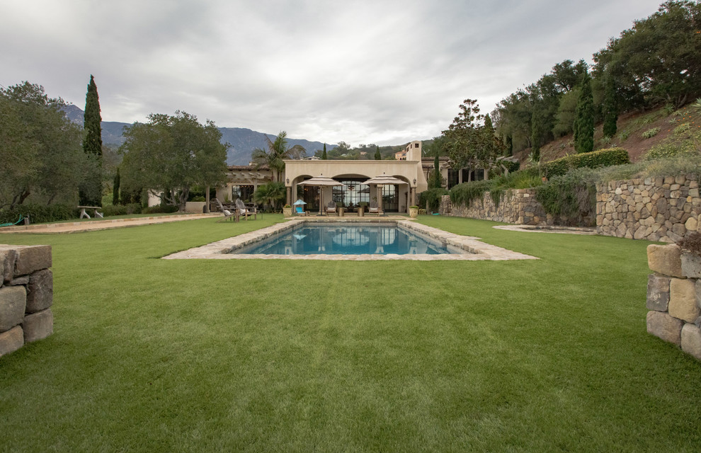 Großer Mediterraner Pool in rechteckiger Form mit Natursteinplatten in Santa Barbara