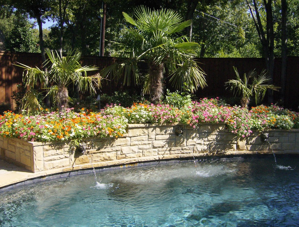 Diseño de piscinas y jacuzzis alargados tropicales de tamaño medio a medida en patio trasero con adoquines de piedra natural
