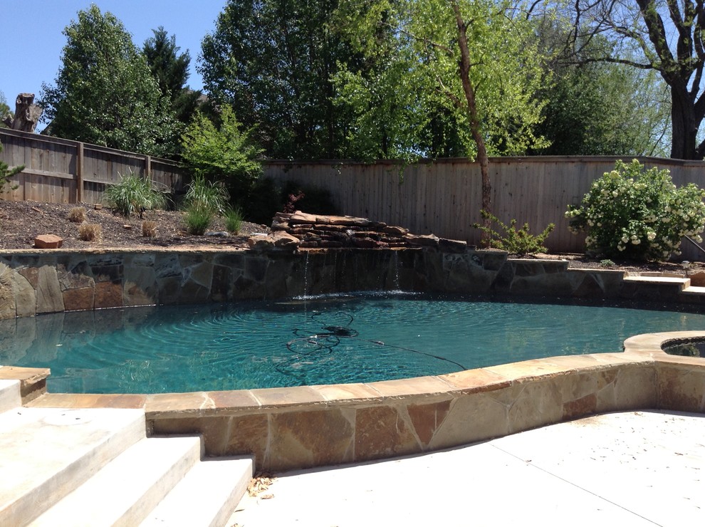 Cette image montre une piscine naturelle et arrière chalet de taille moyenne et sur mesure avec des pavés en pierre naturelle.