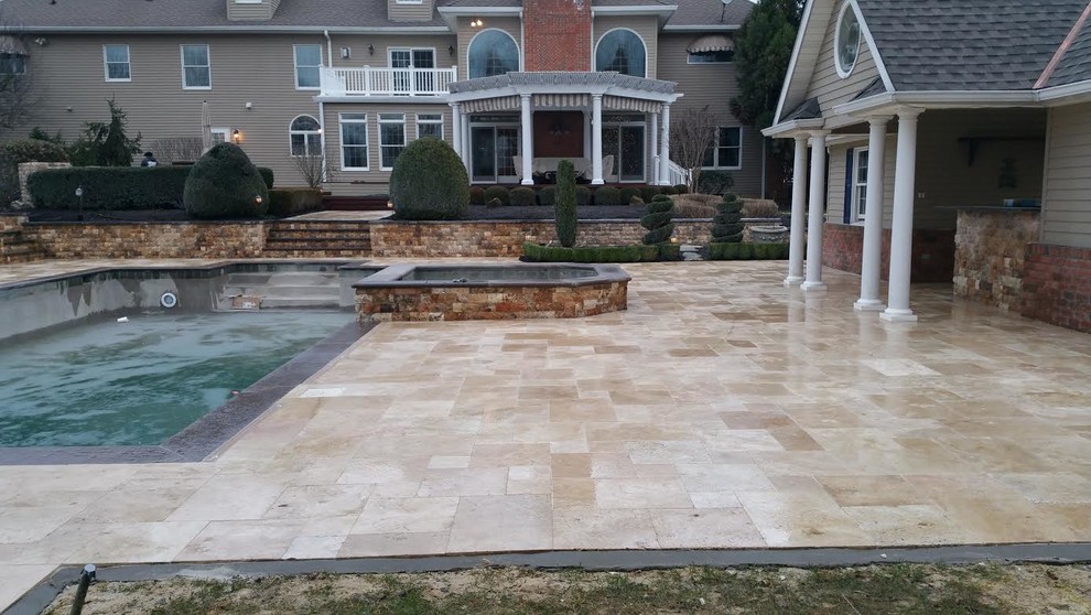 Ejemplo de casa de la piscina y piscina clásica renovada grande rectangular en patio trasero con adoquines de piedra natural