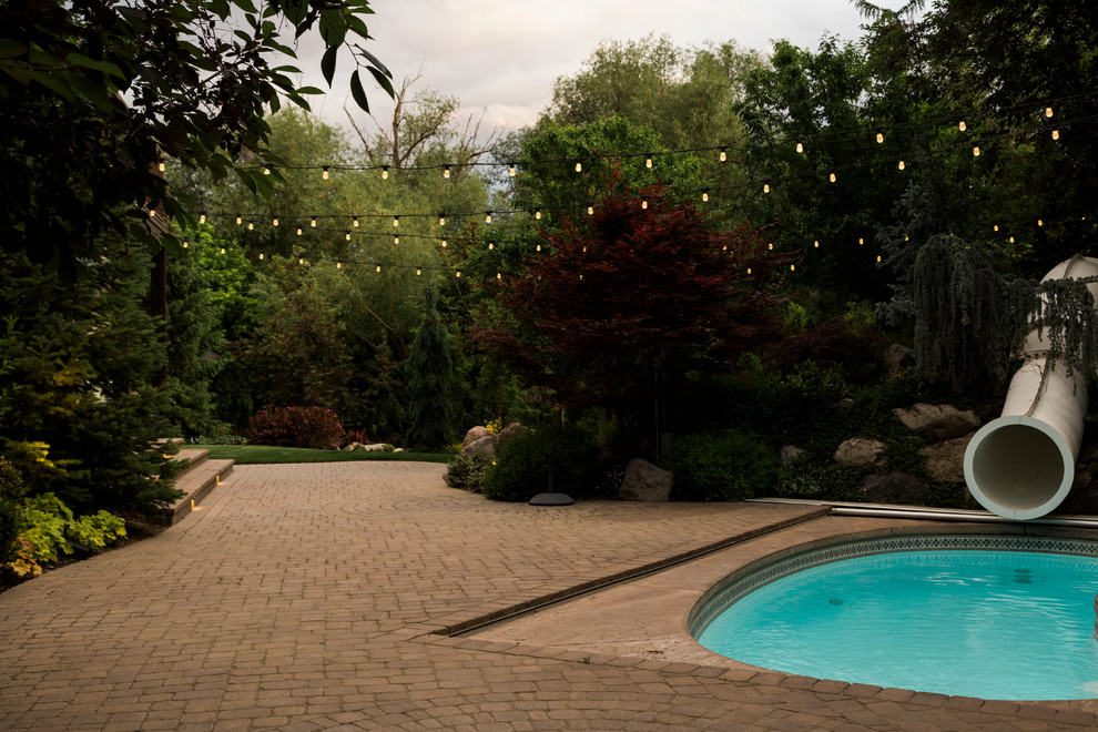 Источник вдохновения для домашнего уюта: бассейн в форме фасоли на заднем дворе в стиле неоклассика (современная классика) с водной горкой и мощением клинкерной брусчаткой