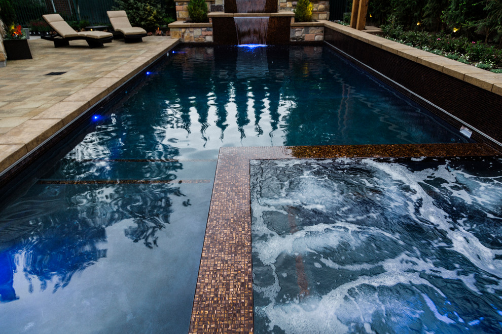 Diseño de piscinas y jacuzzis tradicionales renovados en patio trasero con suelo de hormigón estampado