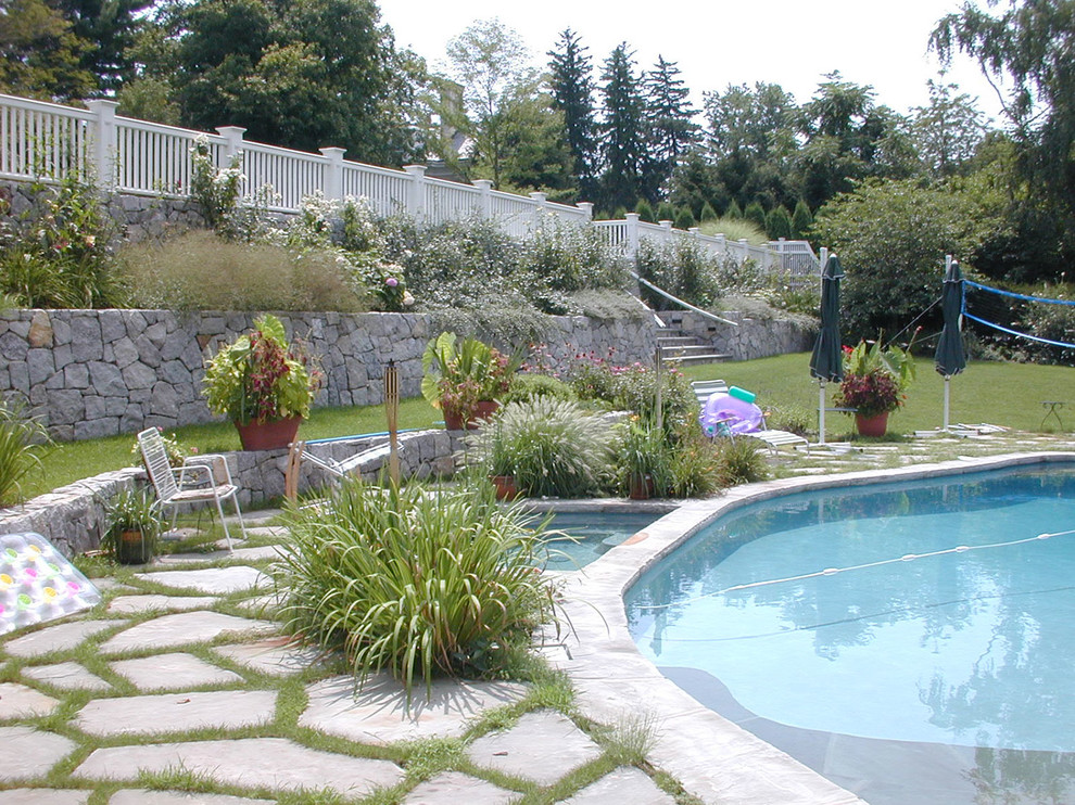 Diseño de piscinas y jacuzzis elevados clásicos renovados de tamaño medio a medida en patio trasero con adoquines de piedra natural
