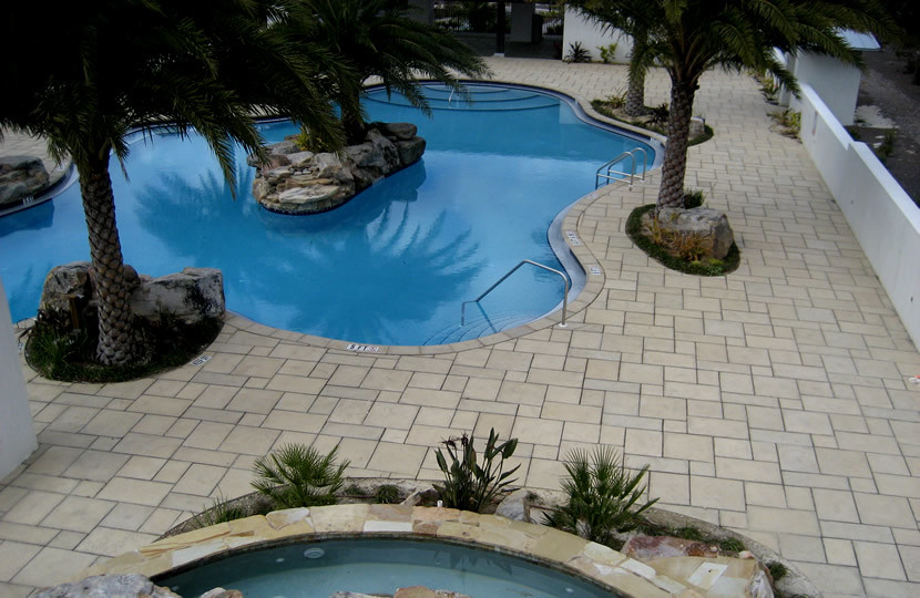 Foto de piscina natural grande a medida en patio con adoquines de hormigón
