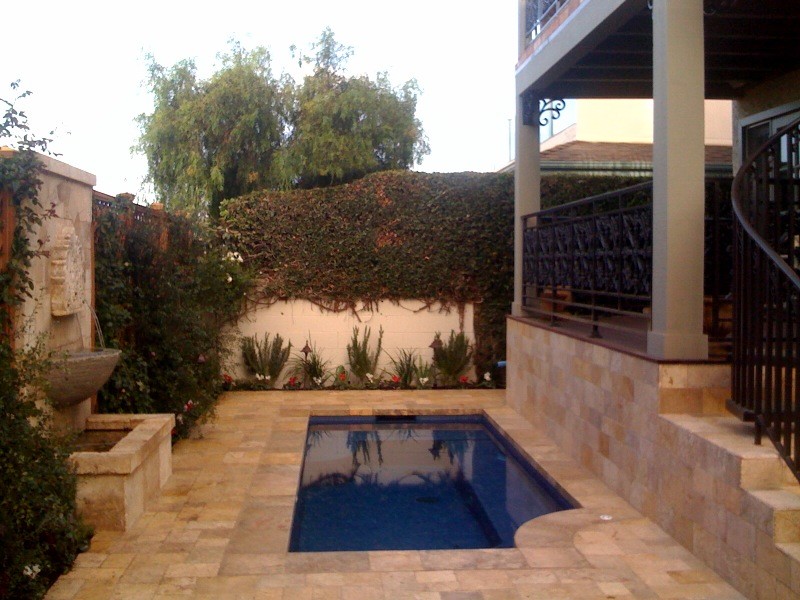 Immagine di una piccola piscina naturale mediterranea rettangolare nel cortile laterale con una vasca idromassaggio e pavimentazioni in pietra naturale