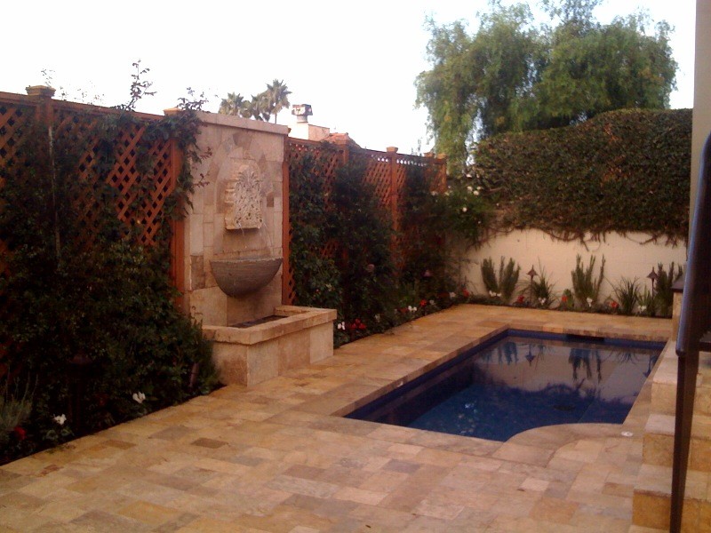 Réalisation d'une petite piscine naturelle et latérale méditerranéenne rectangle avec un bain bouillonnant et des pavés en pierre naturelle.